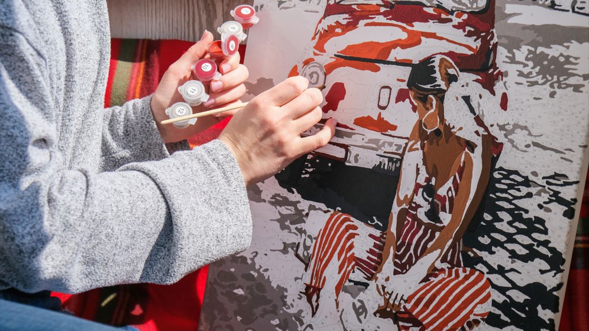 hands painting a paint by numbers kit by Crafty by Numbers