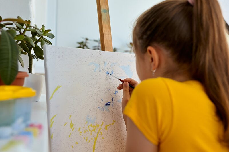 girl using a paint by numbers kit