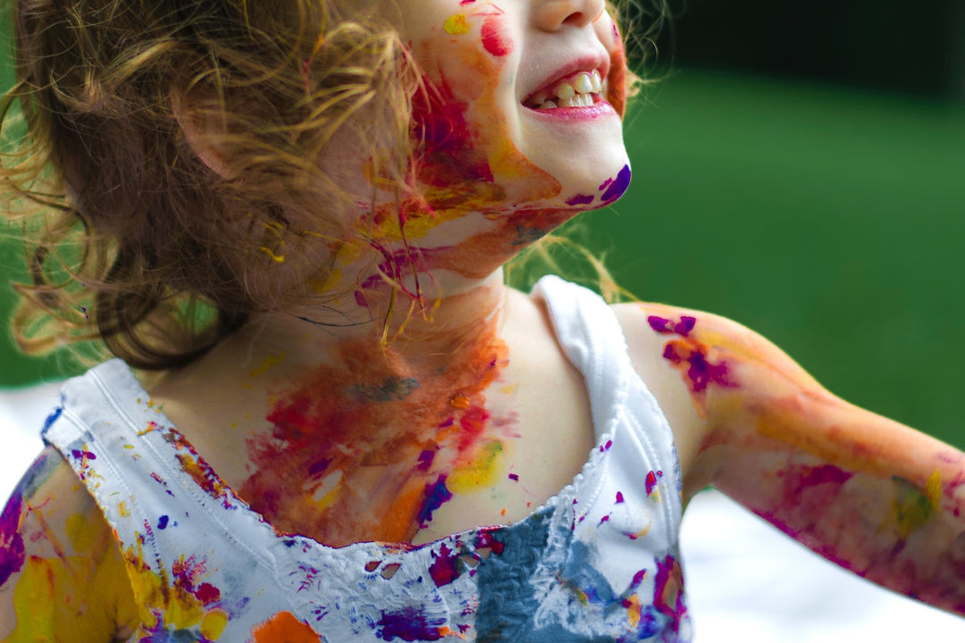 child covered in colorful paint