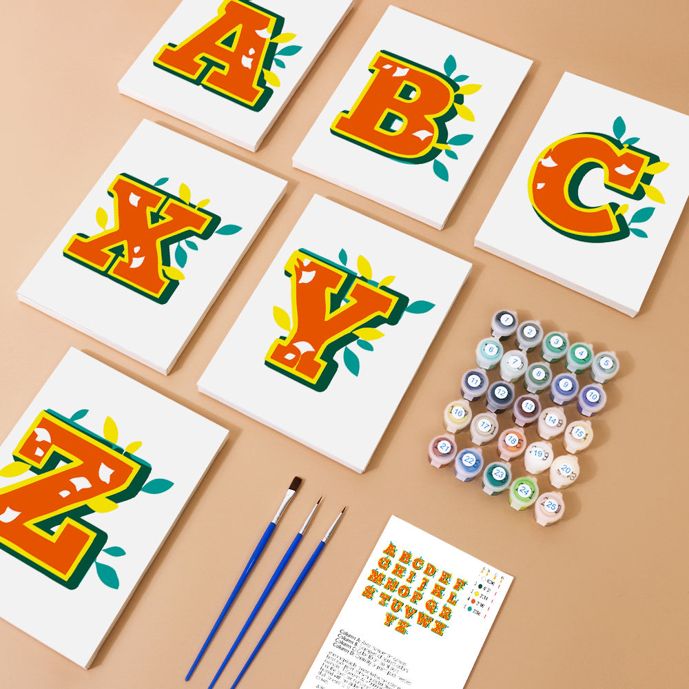 Colorful alphabet letters on white cards with paint bottles and brushes on a beige background