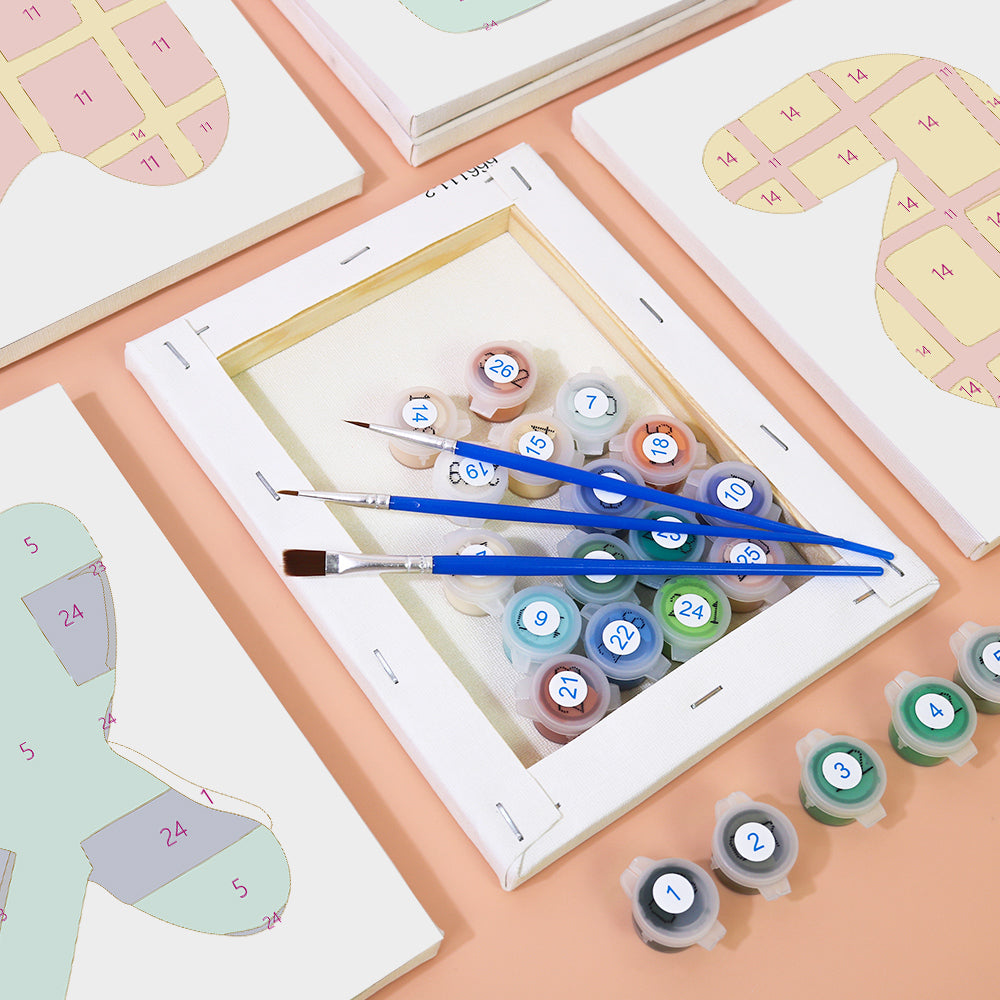 Set of paintbrushes and color swatches on a table with a digital device displaying a grid.