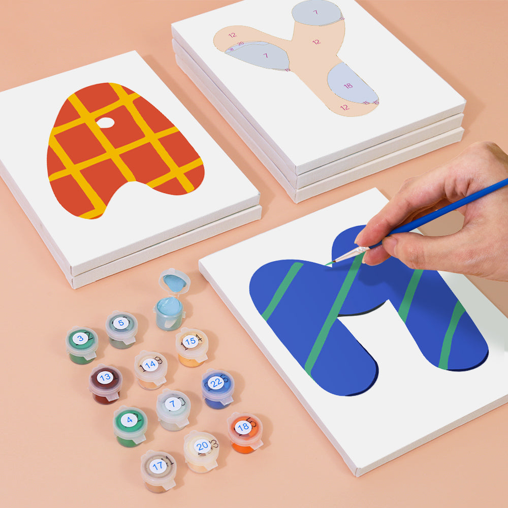 Children's art activity with paint and paper on a peach-colored surface