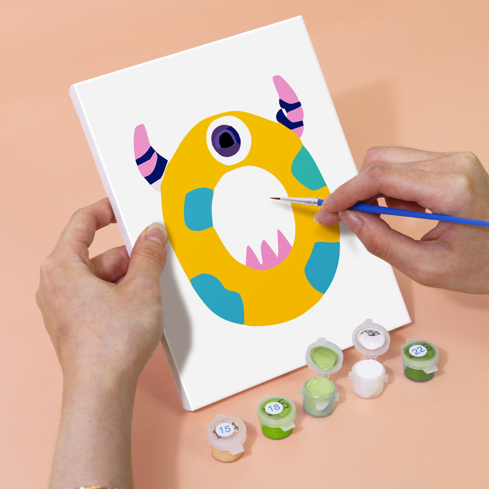 Person painting a colorful letter 'O' with a paintbrush on a white sheet of paper.