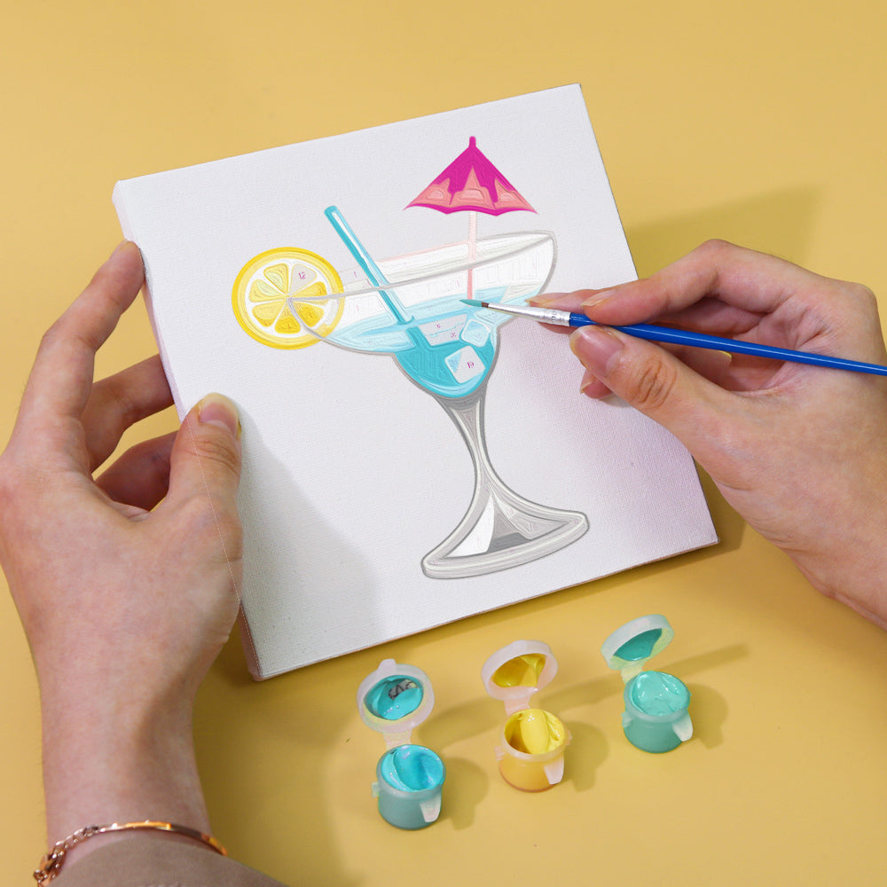 Close-up of a partially painted margarita scene on a mini canvas