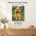 A vertical canvas wall art print showing a fluffy golden-brown dog sitting in a green garden, displayed on a light beige wall above a wooden console table with a vase and books. Text on the image reads 'Picture it in your home.