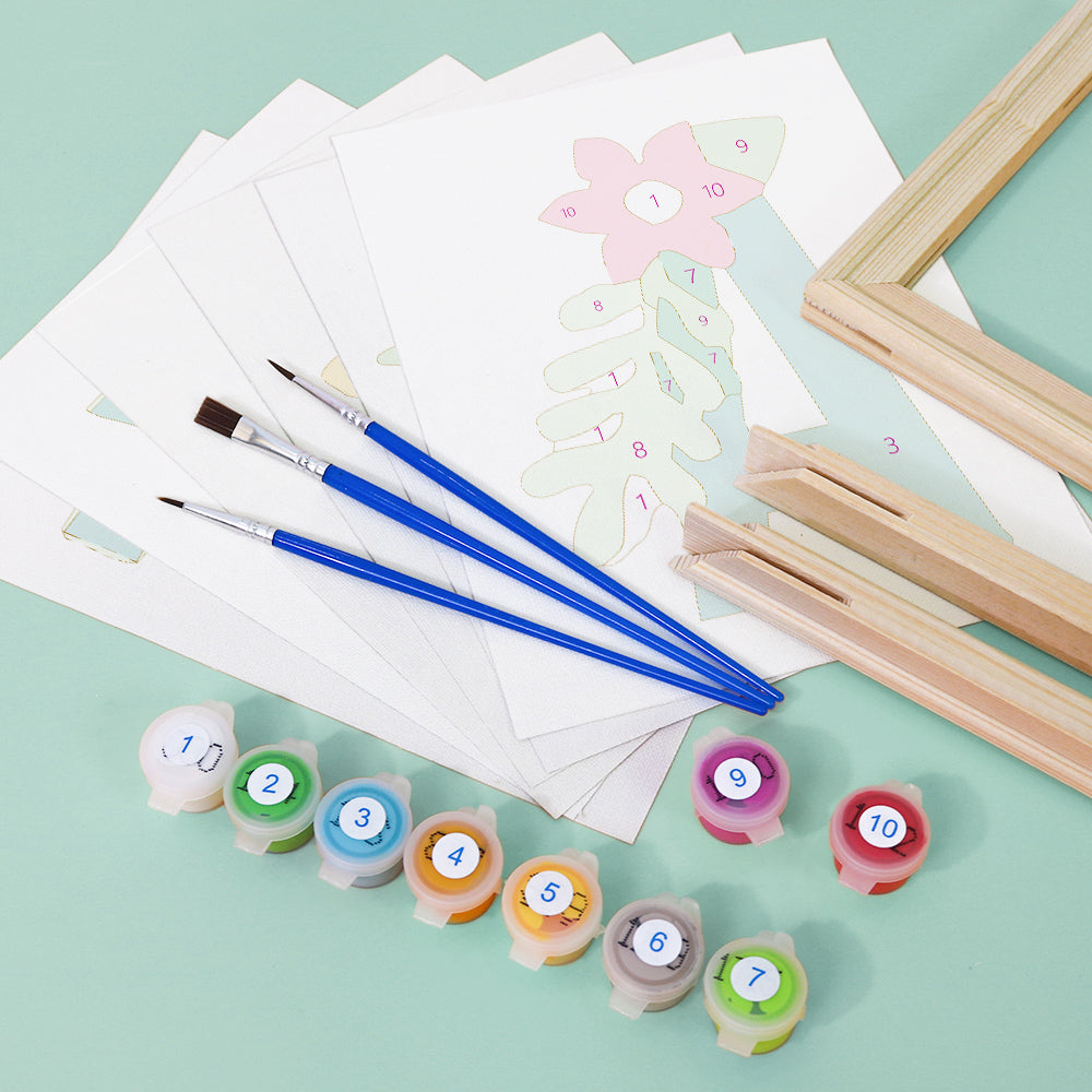 Art supplies including brushes, stamps, and paper on a light green background