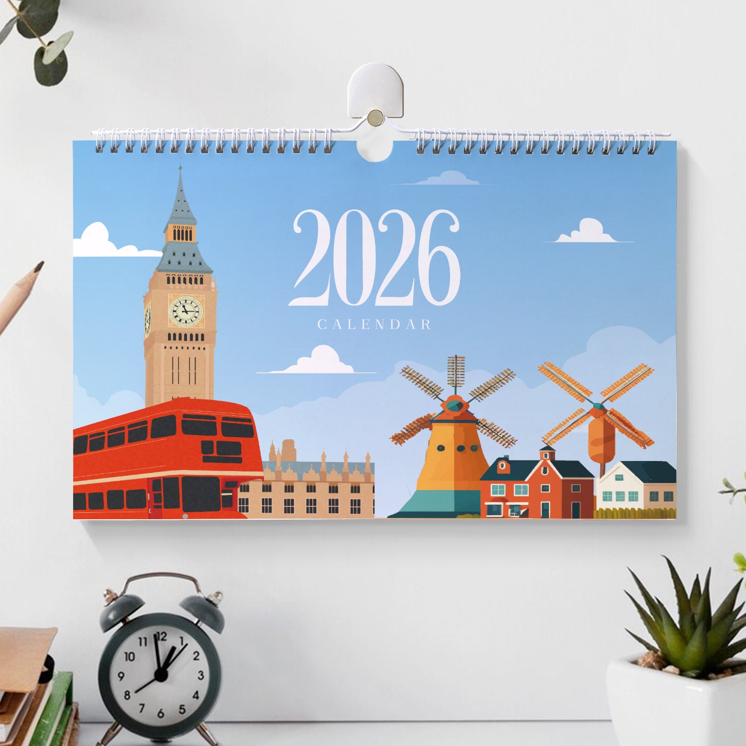 Calendar with 2026 design featuring a clock tower, bus, and windmills on a white wall.