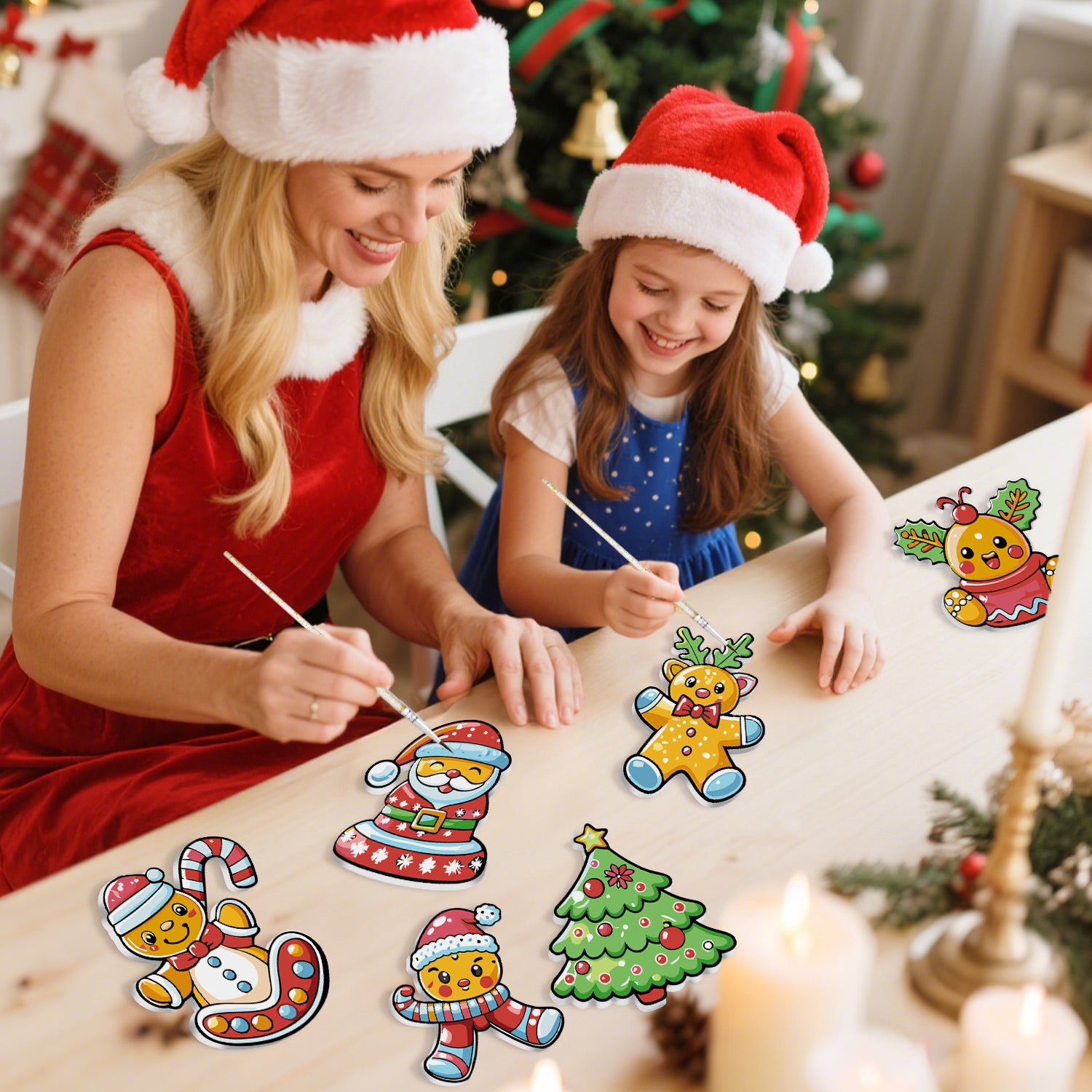 Woman and young girl wearing Santa hats, painting Christmas-themed stickers on a table with a decorated tree in the background.