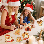 Woman and child decorating gingerbread cookies with a Christmas tree in the background