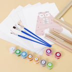 Art supplies including paintbrushes, paint containers, and a pink owl painting on a beige background.
