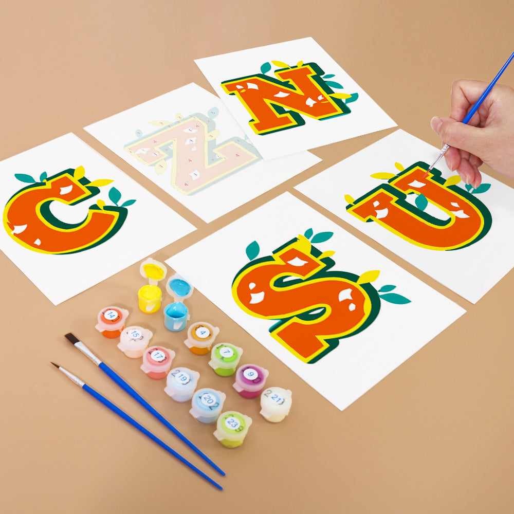 Colorful letter paintings on paper with paint containers and brushes on a brown background