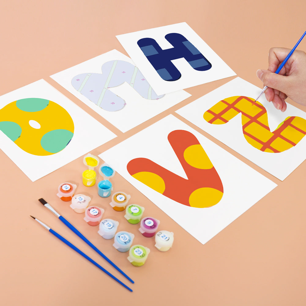 Children's painting activity with letters 'H', 'N', and 'V' on paper, surrounded by paint containers and brushes.