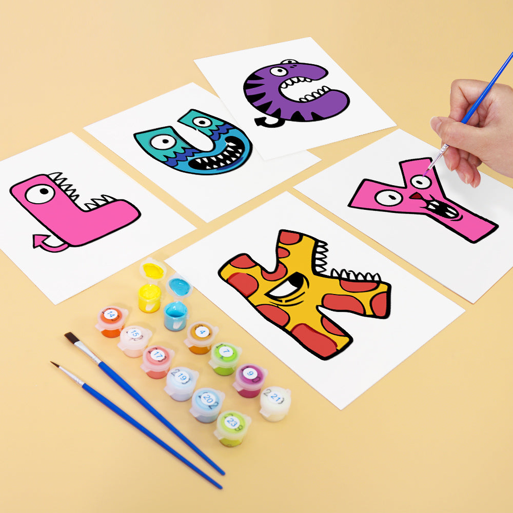 Children's art project with colorful letters U, C, Y, and K on paper, with paint containers and brushes on a beige surface.