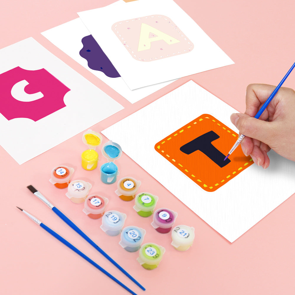 Child painting letters on paper with paint and brushes on a pink background