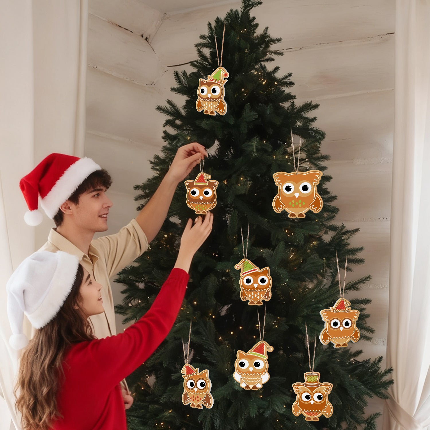 Two people decorating a Christmas tree with owl-shaped ornaments.