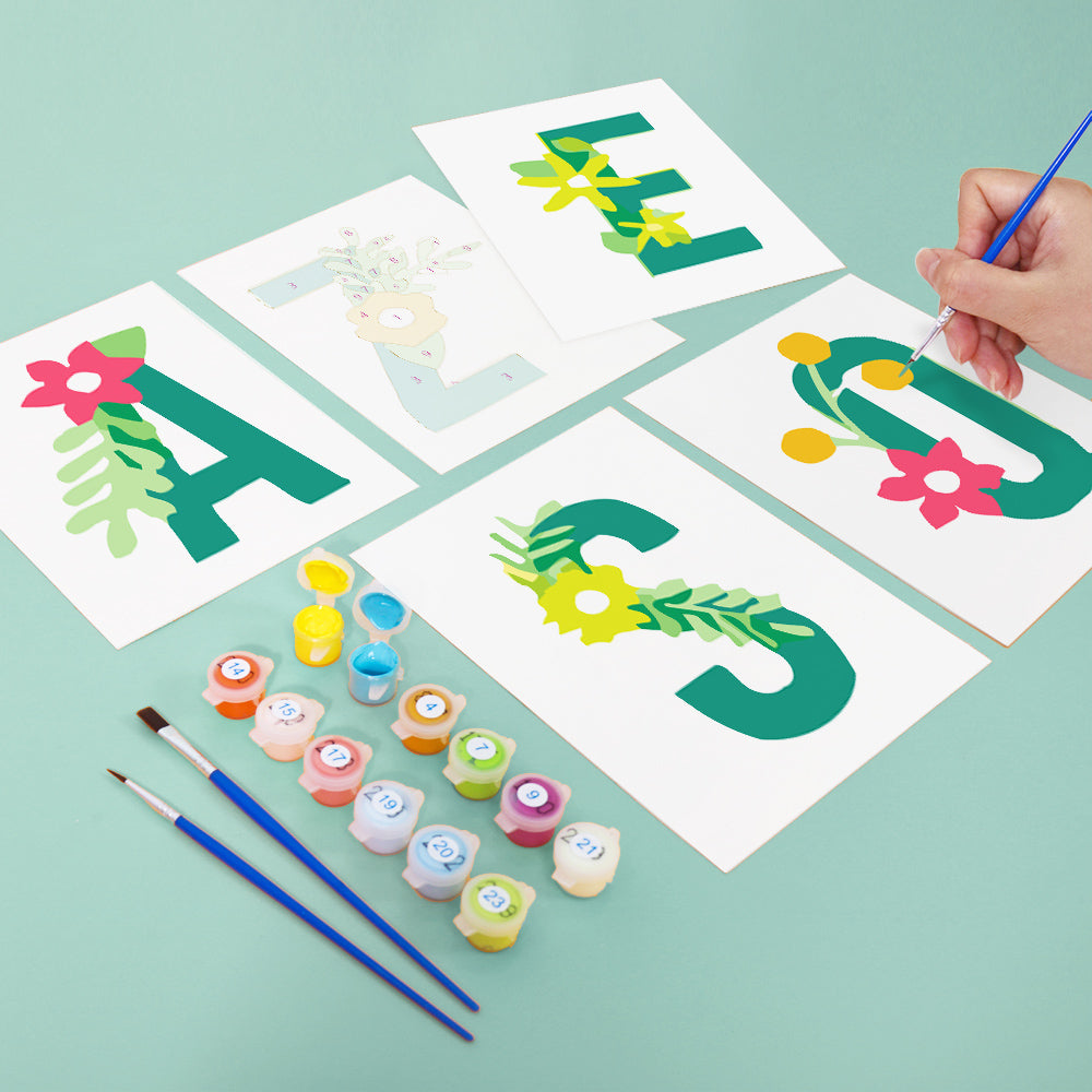 Children's craft activity with letters 'A', 'E', 'S' and paint supplies on a light green background