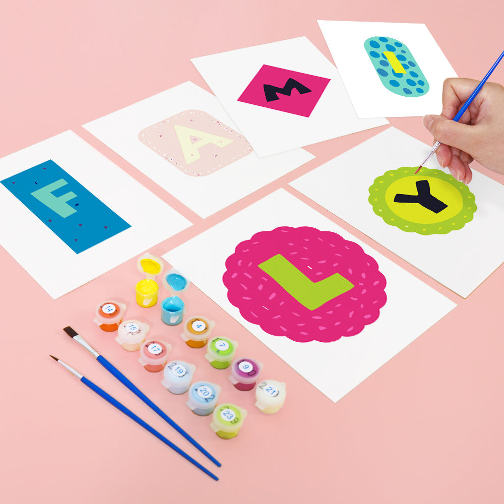 Colorful letter cards with paint containers and brushes on a pink background