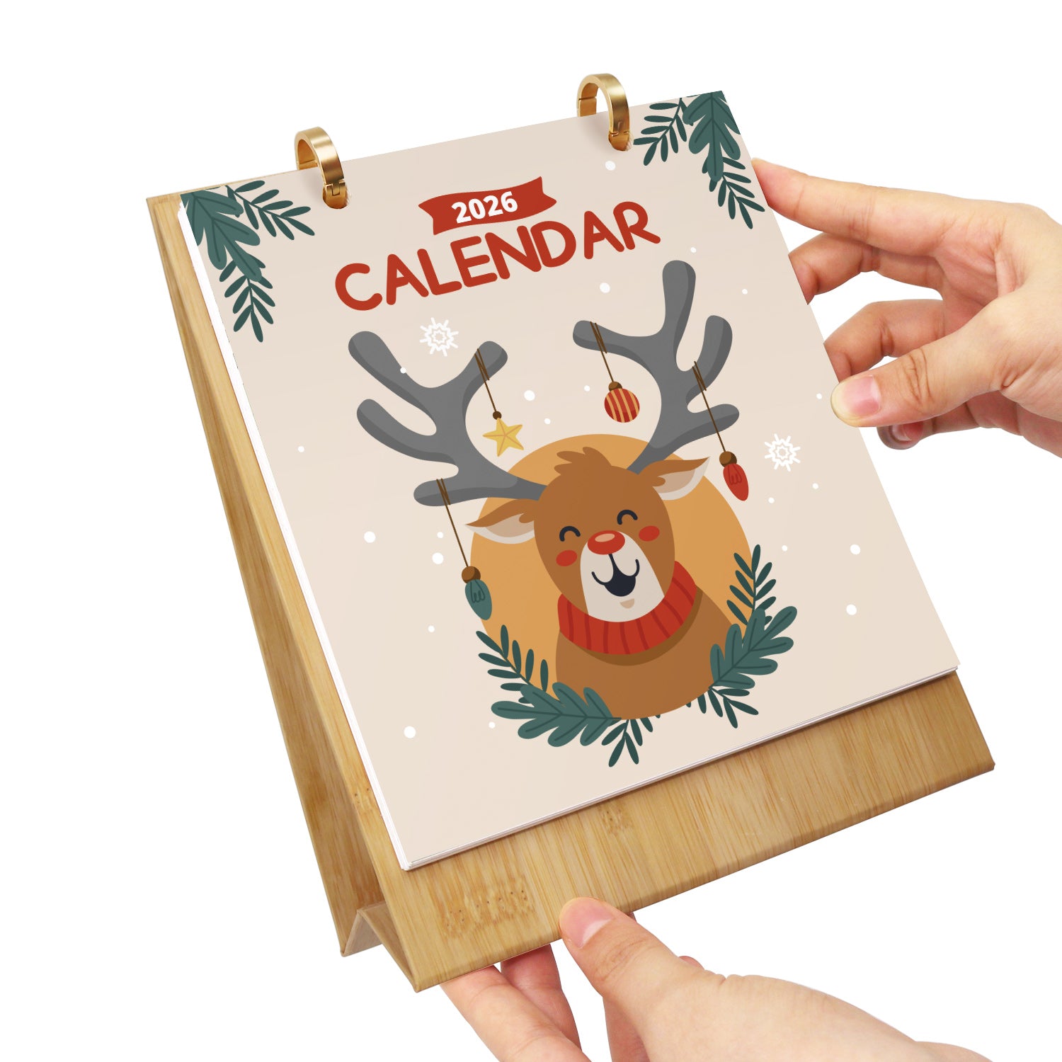 Calendario con un diseño de renos sostenido por una mano sobre un fondo blanco.