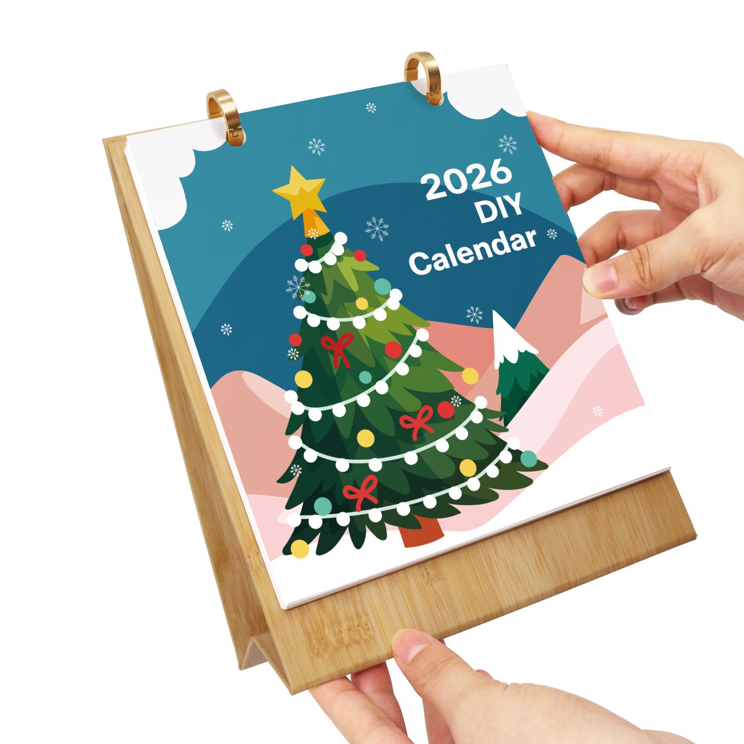 Calendario de bricolaje 2026 con un diseño de árbol de Navidad sostenido por las manos sobre un fondo blanco