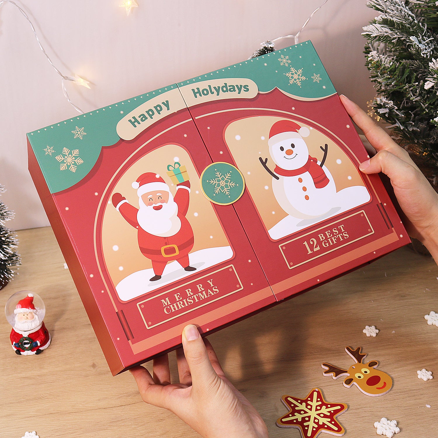 Christmas-themed advent calendar with Santa Claus and snowman illustrations, held by a person.