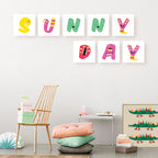 Colorful children's wall art with letters spelling 'SUNNY DAY' in a room setting.