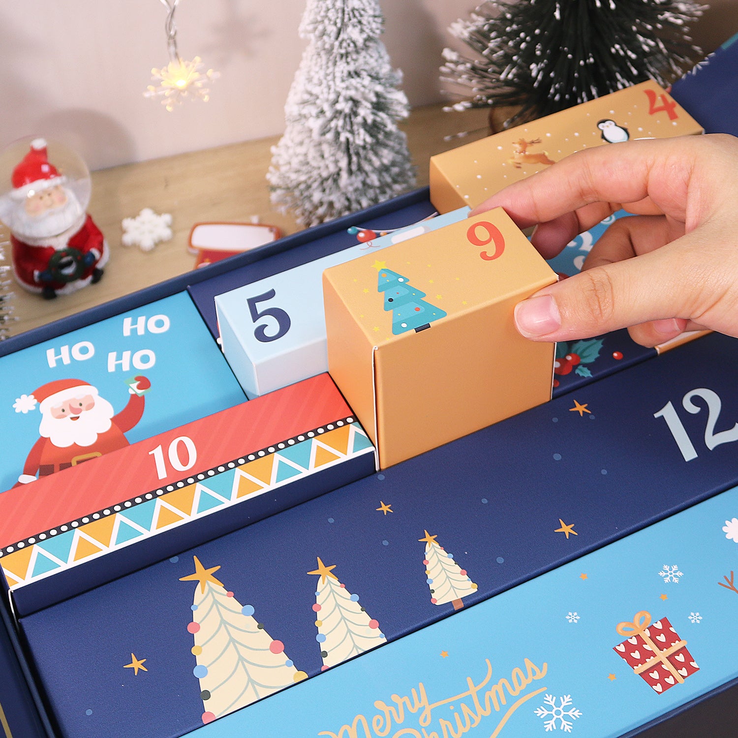 Advent calendar with numbered boxes being opened, festive decorations in the background