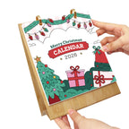 Christmas-themed calendar with festive designs and text, held by a hand on a white background.
