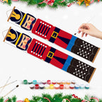 Colorful fabric painting kit with a hand holding a paintbrush, surrounded by Christmas decorations.