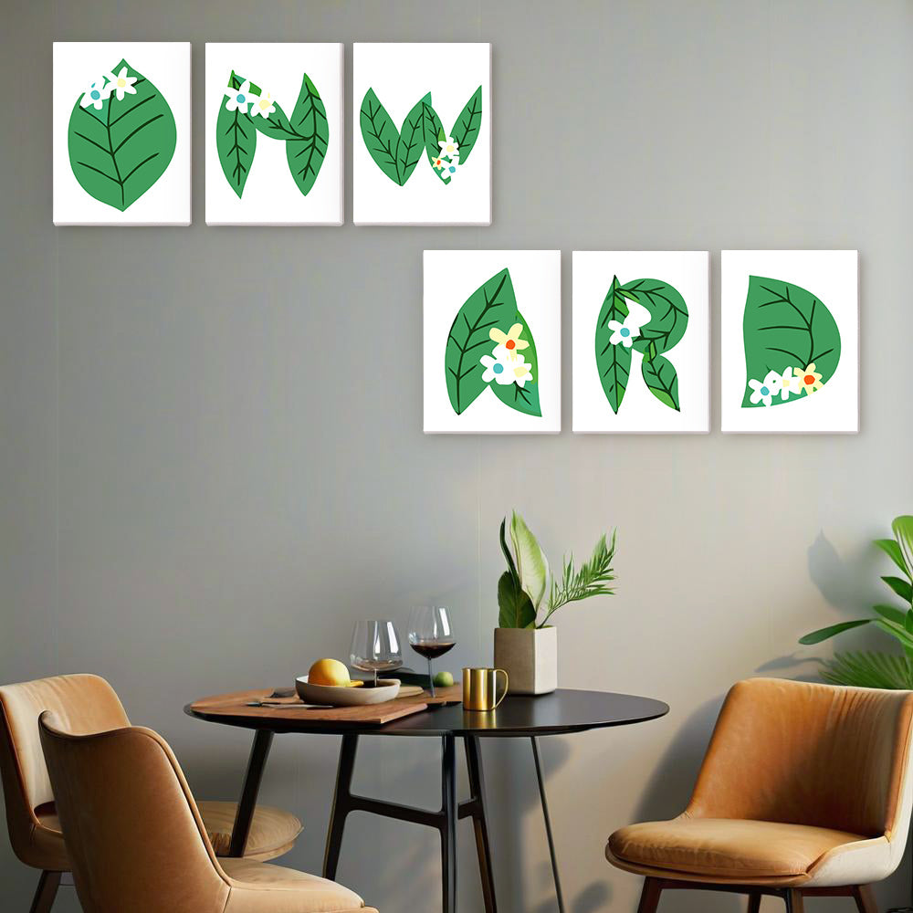 Decorative wall art with green leaves and flowers on a gray wall above a dining table.