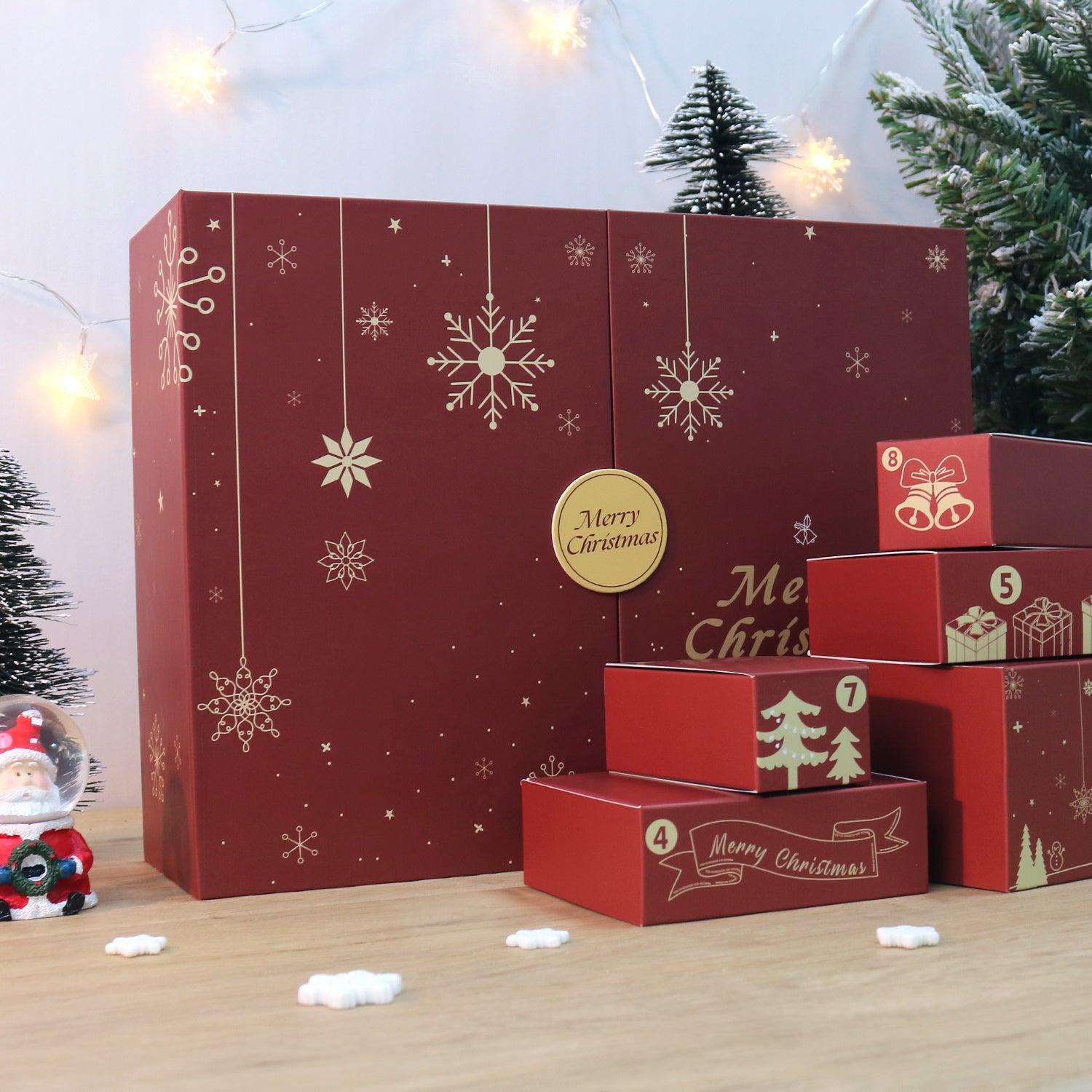 Red Christmas advent calendar with snowflake and tree designs, surrounded by festive decorations.