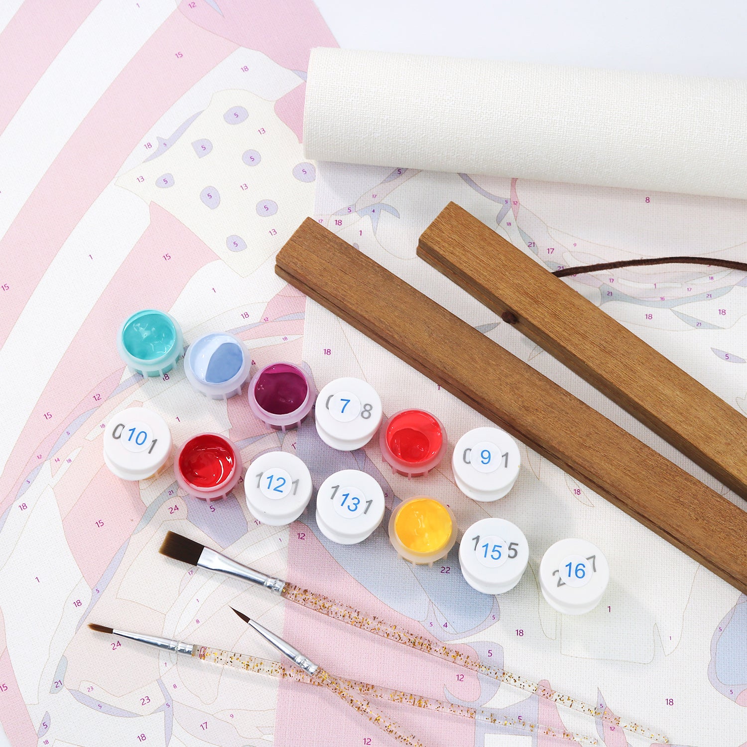 Set of paint pots with numbers, brushes, and wooden sticks on a patterned surface