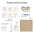 Set of art supplies including acrylic paints, brushes, linen canvas, and other materials on a white background.