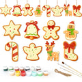 Set of Christmas-themed ceramic decorations with paint supplies on a white background