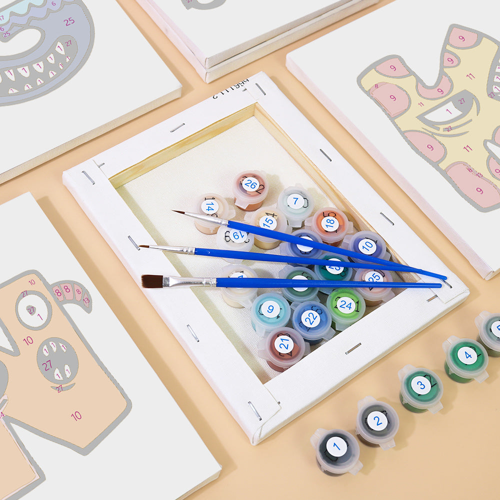 Set of paint tubes and brushes on a table with craft materials