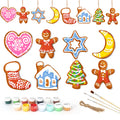 Set of Christmas-themed ceramic decorations with painting supplies on a white background