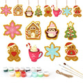 Set of Christmas-themed ceramic decorations with painting supplies on a white background
