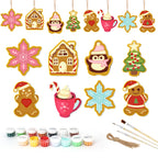 Set of Christmas-themed ceramic decorations with painting supplies on a white background
