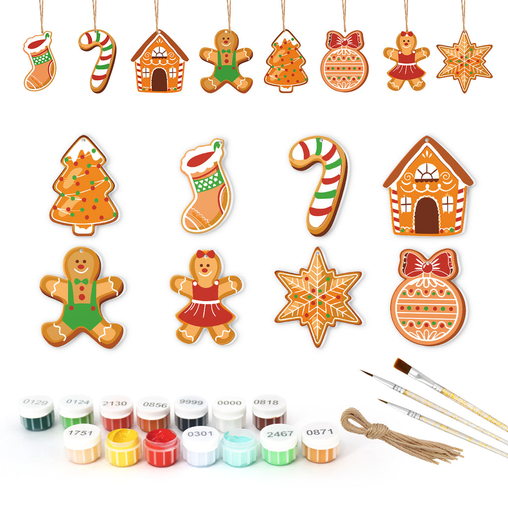 Collection of Christmas-themed cookie cutters with painting supplies on a white background