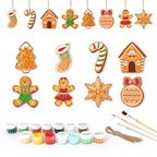 Collection of Christmas-themed cookie cutters with painting supplies on a white background