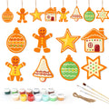 Set of Christmas-themed decorations including gingerbread men, stars, and houses with painting supplies on a white background.