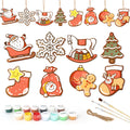 Set of Christmas-themed ceramic decorations with painting supplies on a white background