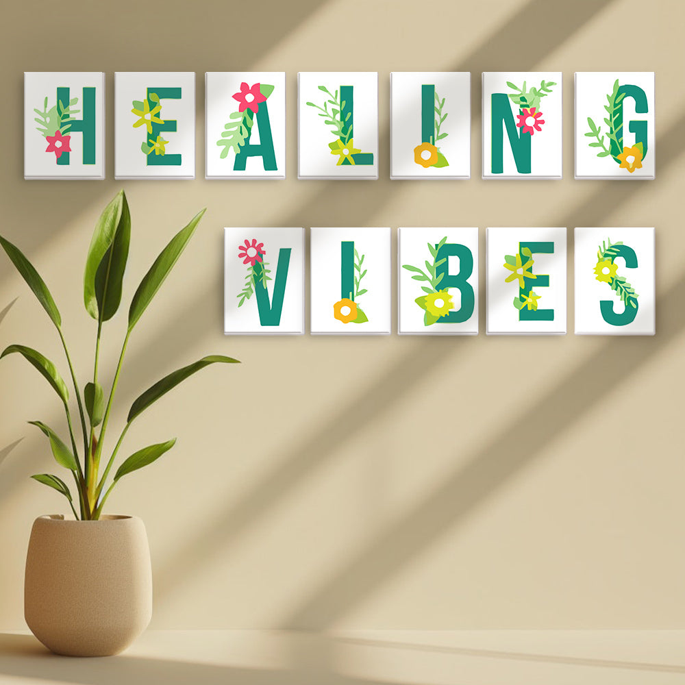 Decorative wall art with 'HEALING VIBES' text on a beige wall with a plant.