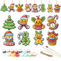 Set of Christmas-themed ceramic decorations with painting supplies on a white background