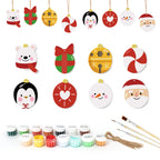 Set of Christmas-themed ceramic ornaments with painting supplies on a white background