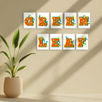 Decorative wall art with 'GREEN LEAF' text on a beige wall with a plant.