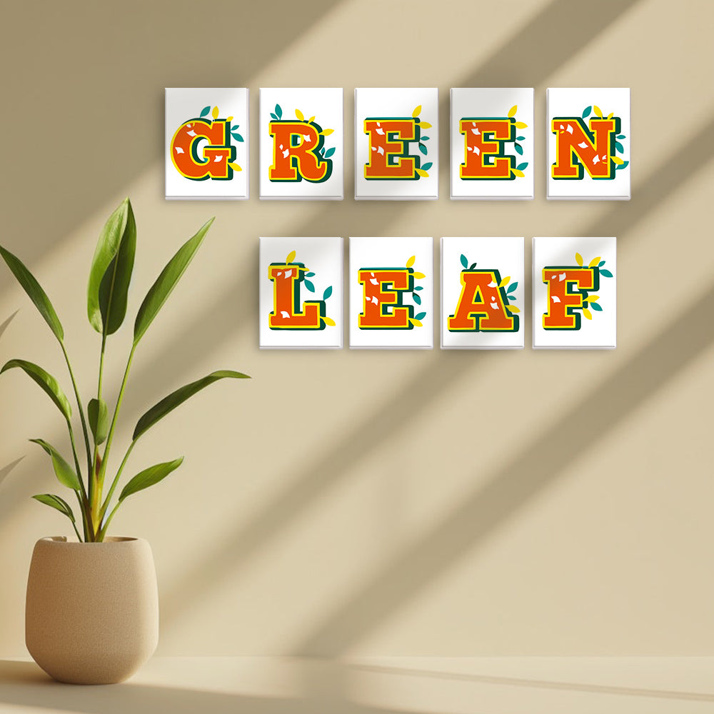 Decorative wall art with 'GREEN LEAF' text on a beige wall with a plant.