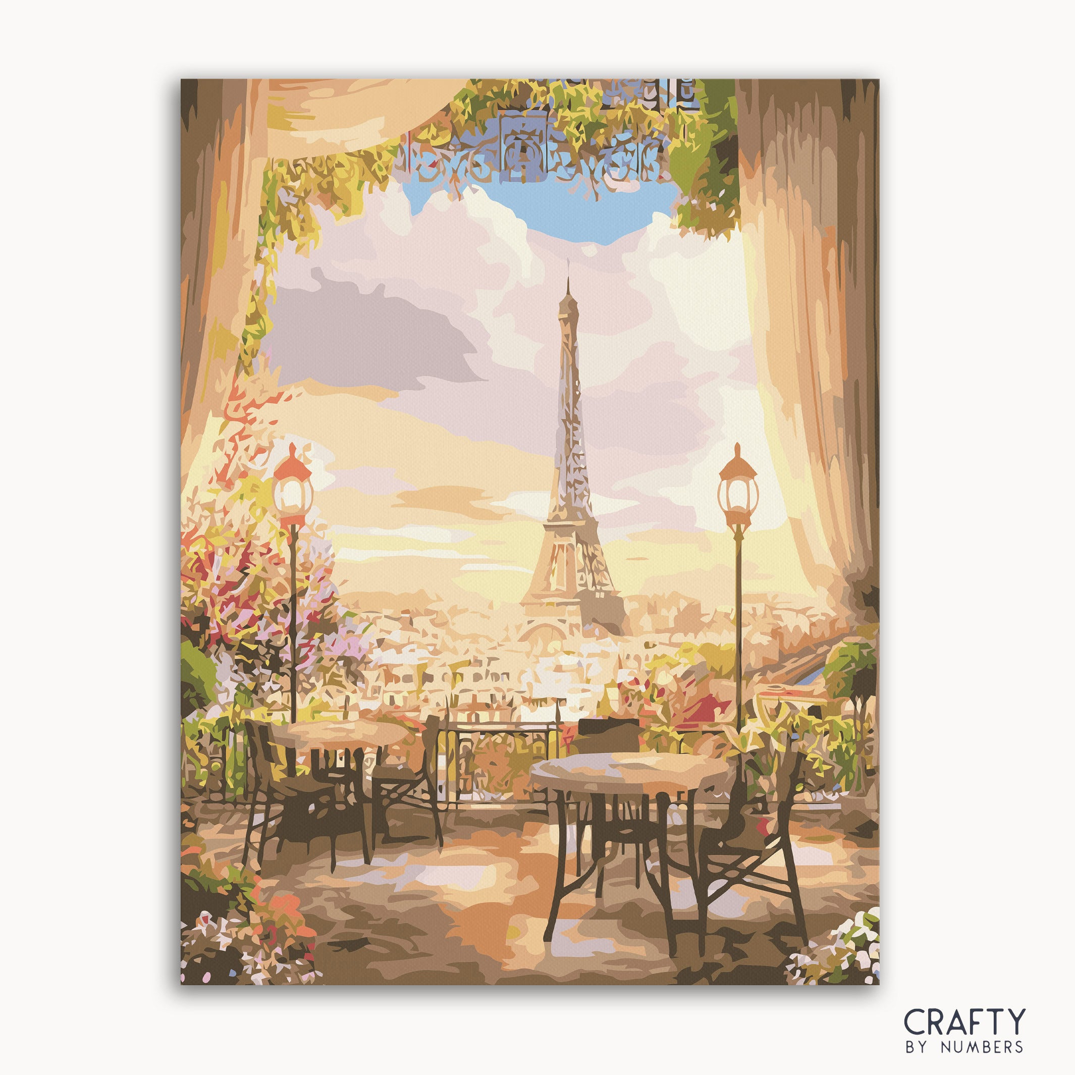 A paint-by-numbers kit depicting a cafesé scene with the Eiffel Tower in the background, tables set with flowers, and a sunset sky.