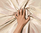 A hand gripping cream-colored bedsheets, drawing the fabric into deep folds.