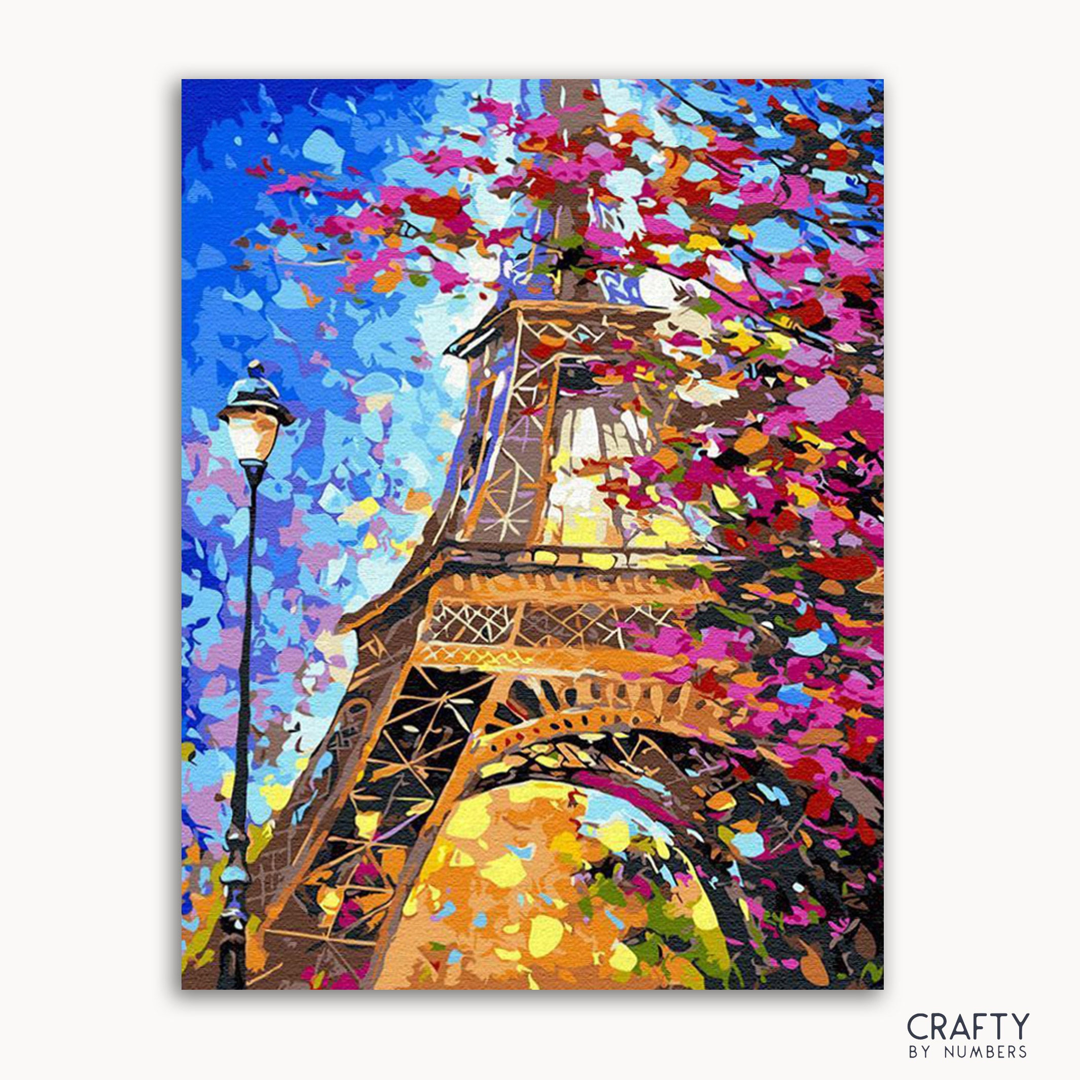 A colorful painting depicting the Eiffel Tower with a floral motif in the foreground, under a blue sky with accents of yellow, pink, and green.