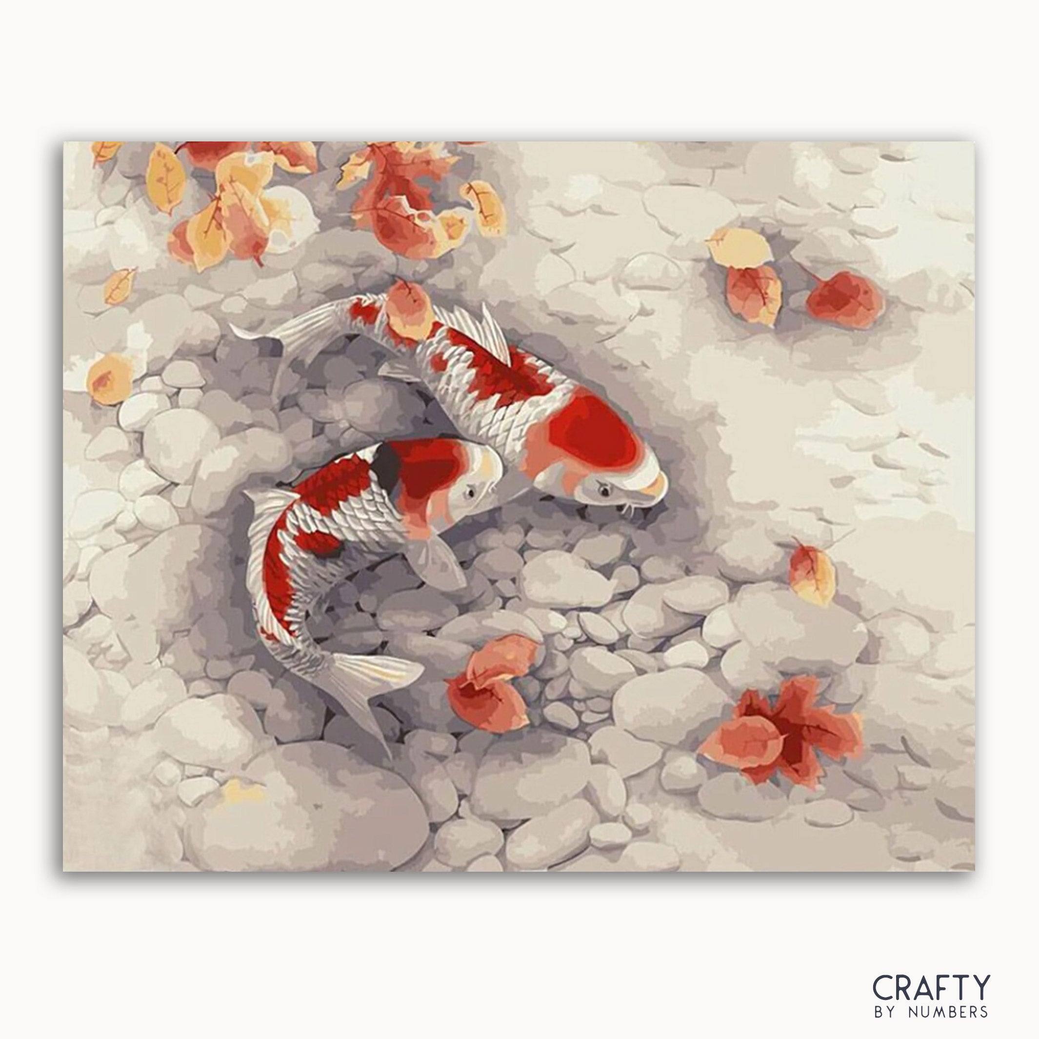 A paint by numbers kit depicting orange and white koi fish swimming in water with rocks and leaves.